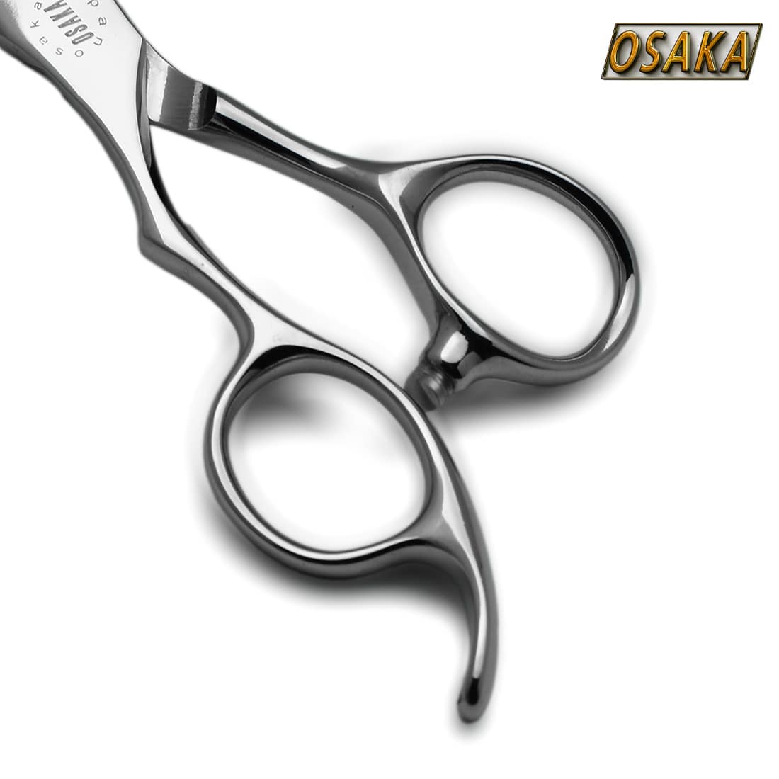 Gros plan sur le manche inversé des ciseaux OSAKA MTL pour gauchers – finition acier poli, anneaux ergonomiques et repose-doigt courbé à gauche